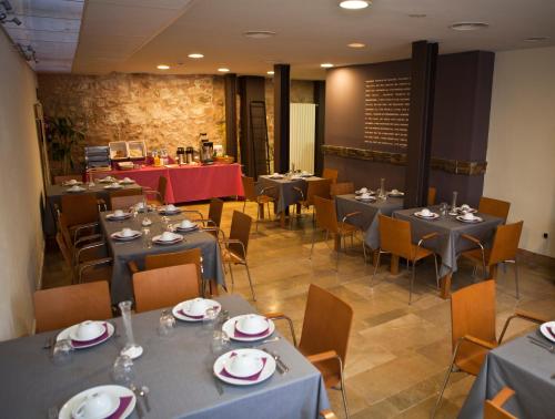 un comedor con mesas y sillas en un restaurante en Hospederia Porta Coeli, en Sigüenza
