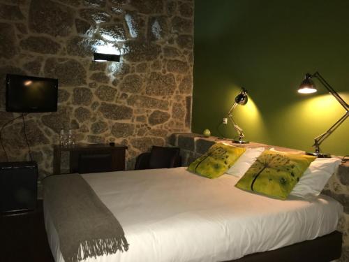 a bedroom with a bed with two yellow pillows at Quinta do Medronheiro Hotel Rural in Viseu