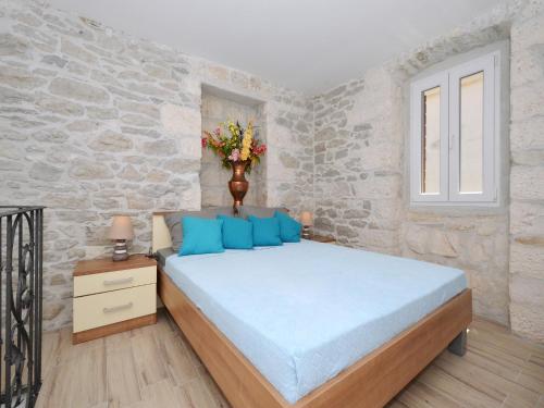 1 dormitorio con cama y pared de piedra en Apartment Petrovic en Trogir