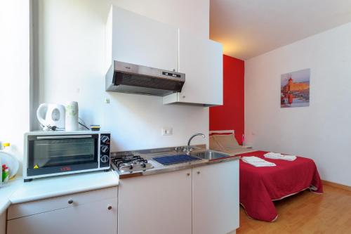 a kitchen with a stove and a microwave and a table at Appartamenti Trapani Mare in Trapani
