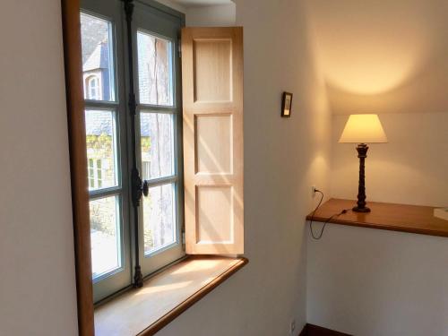 a window in a room with a lamp next to it at Le Domaine de Belleville in Dragey