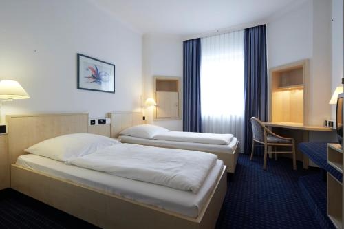 Llit o llits en una habitació de IntercityHotel Ulm