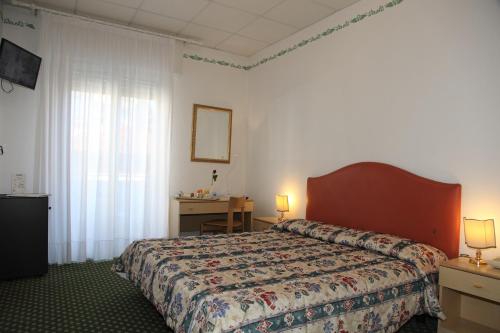 a hotel room with a bed and a desk at Hotel Villa Rosa in Grado