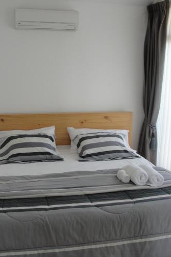 a bed with two pillows on top of it at Hotel Boutique La Angostura in Ica
