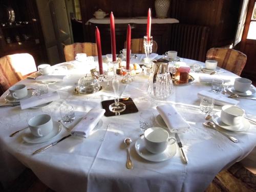 a table with a white table cloth and candles on it at Chateau de Vaux in Yvré-lʼÉvêque