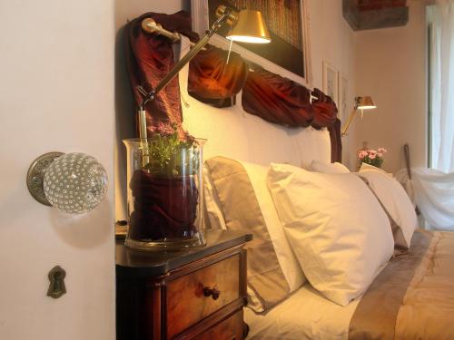 a lamp on a night stand next to a bed at Villa Ottolenghi Wedekind in Acqui Terme
