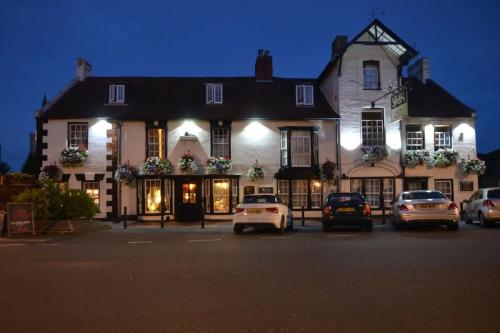 a large building with cars parked in front of it at The Lion Hotel in Buckden