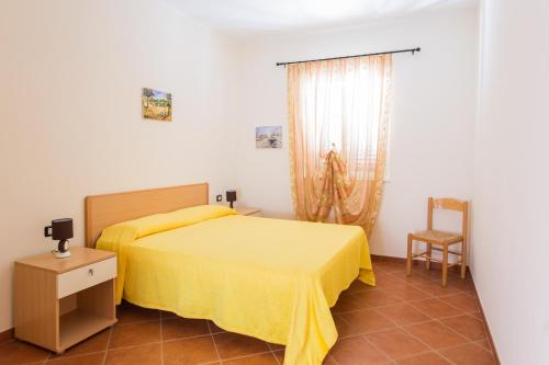 a bedroom with a yellow bed and a chair at Villa Calma in Vieste