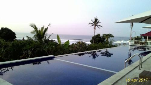 a swimming pool with a view of the ocean at Gubug Balian Beach Bungalow in Selemadeg