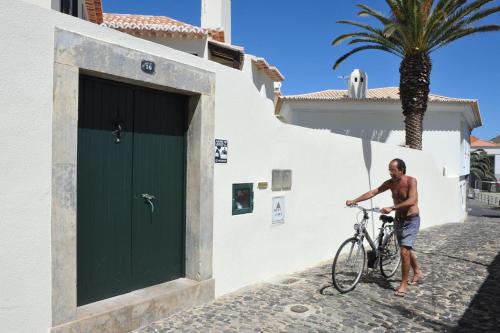 um homem segurando uma bicicleta em frente a um edifício em 16 Porto Santo Apartments em Porto Santo