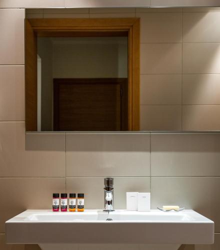a bathroom with a sink and a mirror at Aegli Hotel Volos in Volos