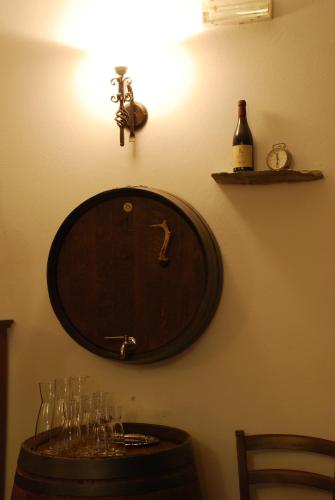 a clock on a wall with glasses on a table at Agriturismo Vecchio Torchio in Canelli