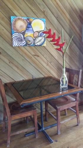 a wooden table with a vase with a flower on it at Apartments Chez Milady in Utila