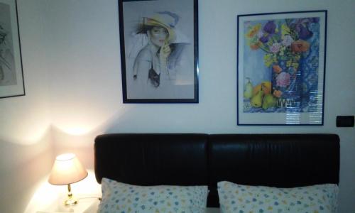 a bedroom with a couch and two pictures on the wall at Residenza del Pascià - Appartamento Camphora in Oggebbio