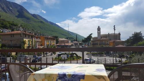 a table on a balcony with a view of a town at Hotel Firenze in Malcesine