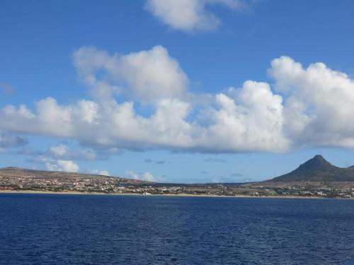 a large body of water with a mountain in the background at 16 Porto Santo Apartments in Porto Santo