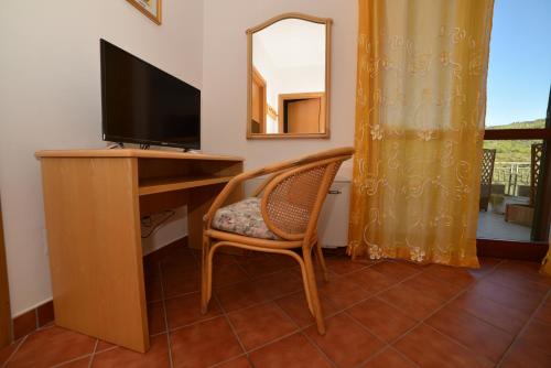 a room with a desk with a television and a chair at La Locanda di Campagna in Agropoli