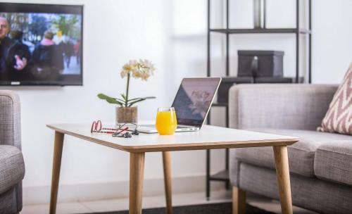 a coffee table with a laptop and a glass of orange juice at Nordic Villa in Abuja