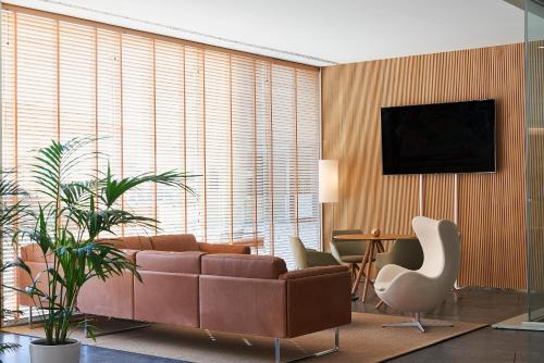 a living room with a couch and a tv on a wall at Melia Palma Bay in Palma de Mallorca