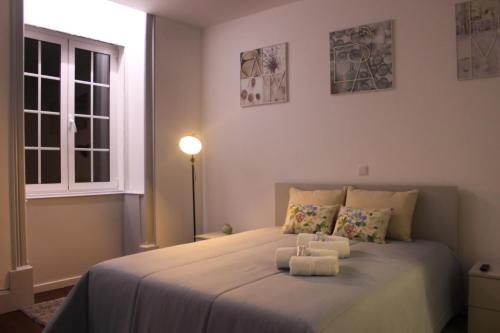 a bedroom with a bed with two towels on it at Charme e Alegria in Viseu