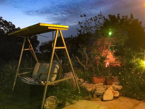 a swing in a yard at night at Country lodging in Manot in Manot