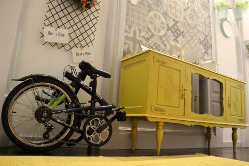 a bike is parked next to a yellow cabinet at Charme e Alegria in Viseu
