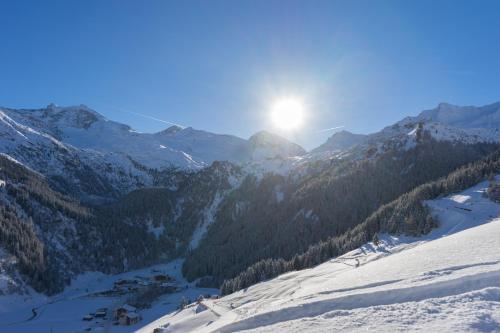 a snow covered mountain with the sun in the sky at Fernerblick Apartments in Tux