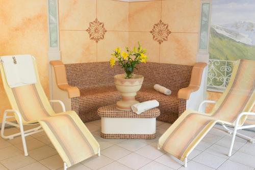 a room with two chairs and a vase with flowers at Fernerblick Apartments in Tux