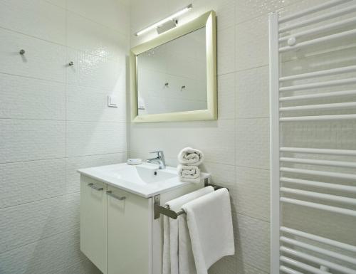 a white bathroom with a sink and a mirror at Stars of Zagreb Apartments in Zagreb