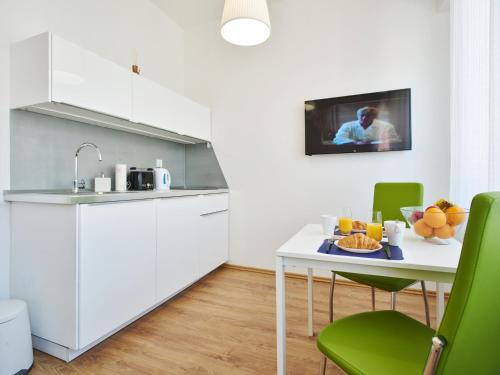 a kitchen with a white table and green chairs at Stars of Zagreb Apartments in Zagreb