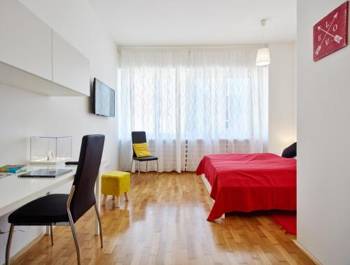 a bedroom with a red bed and a desk and a window at Stars of Zagreb Apartments in Zagreb