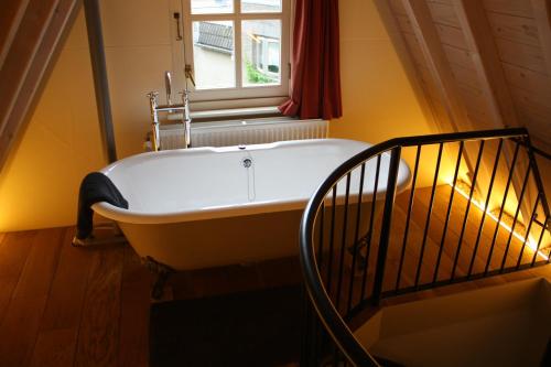 a bath tub in a room with a window at De Hemel De Kracht van Ambacht in Nijmegen