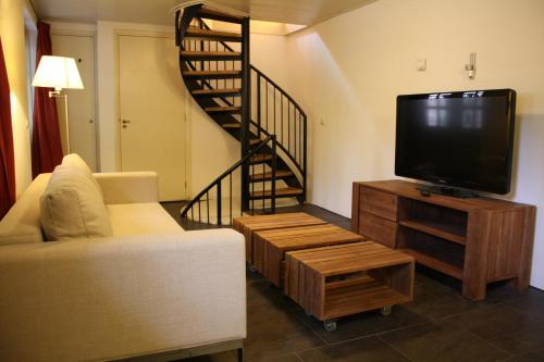 a living room with a tv and a staircase at De Hemel De Kracht van Ambacht in Nijmegen