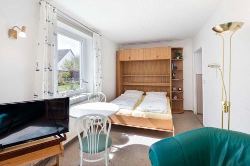 ドゥネンにあるKirchners Ferienwohnungのベッドルーム(ベッド1台、テレビ、テーブル付)