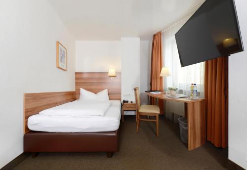 ein Hotelzimmer mit einem Bett und einem Schreibtisch in der Unterkunft Hotel Bayerisch Meran in Bad Feilnbach