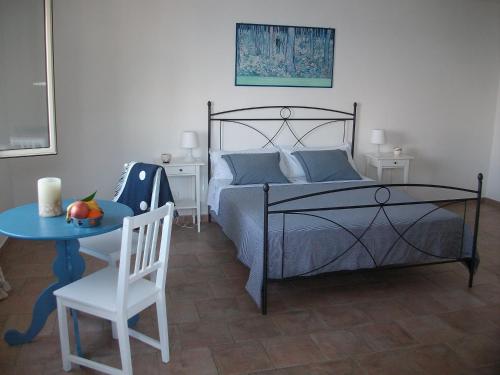 a bedroom with a bed and a table with a chair at Baia Scirocco Bed and Breakfast in Peschici