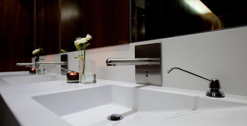 a white bathroom with two sinks and a mirror at Hotel Villa Batalha in Batalha