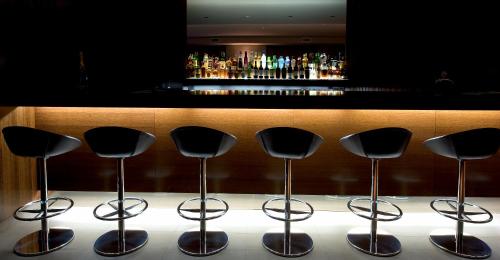 a row of stools in front of a bar at Hotel Villa Batalha in Batalha