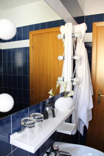 baño con lavabo y pared de azulejos azules en Hotel Allo Zodiaco, en Andalo