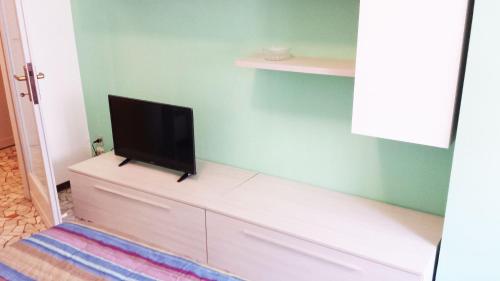 un televisor sentado en la parte superior de un tocador en una habitación en Edolo Apartment en Milán