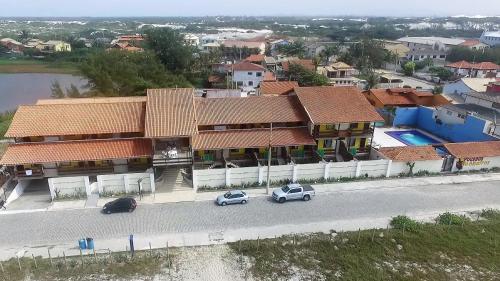 two cars are parked in front of a house at Pousada do Albatroz in Cabo Frio