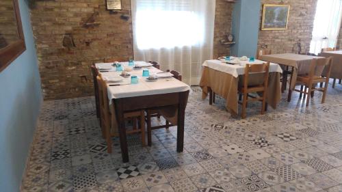 a dining room with two tables and chairs in a restaurant at Relais Il Giardino fra gli Ulivi in Torino di Sangro