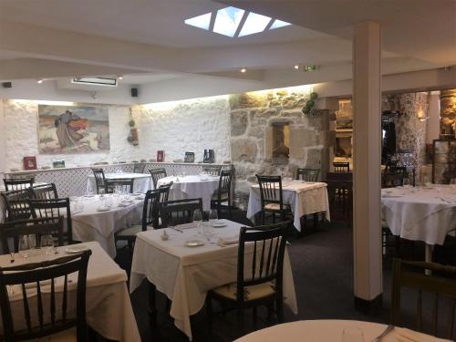 Hôtel de la Presqu'ile في كروزون: غرفة طعام مع طاولات وكراسي مع قماش الطاولة البيضاء