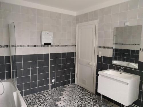 La salle de bains est pourvue d'un lavabo, de toilettes et d'un miroir. dans l'établissement La Maison Boulonnaise, à Boulogne-sur-Mer
