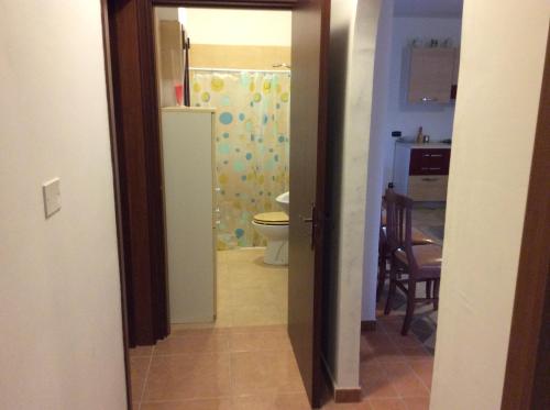 an open door to a bathroom with a toilet at Villa Matine in Specchia