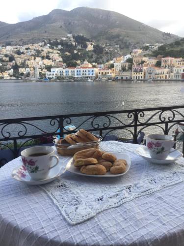 a table with a plate of pastries and cups of coffee at Nikolitsi Studios in Symi