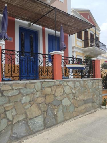a house with a stone wall and a balcony at Nikolitsi Studios in Symi