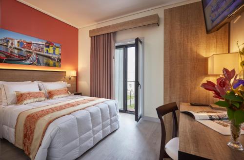 a bedroom with a bed and a desk and a table with a desk at Suites & Hostel Cidade Aveiro in Aveiro