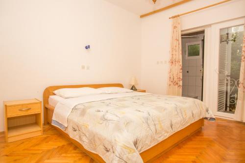 a bedroom with a large bed and a window at Guesthouse Neven Paklenica in Starigrad-Paklenica