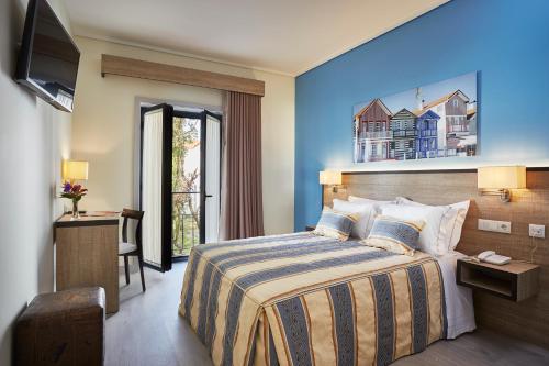 una camera d'albergo con letto e TV di Suites & Hostel Cidade Aveiro ad Aveiro